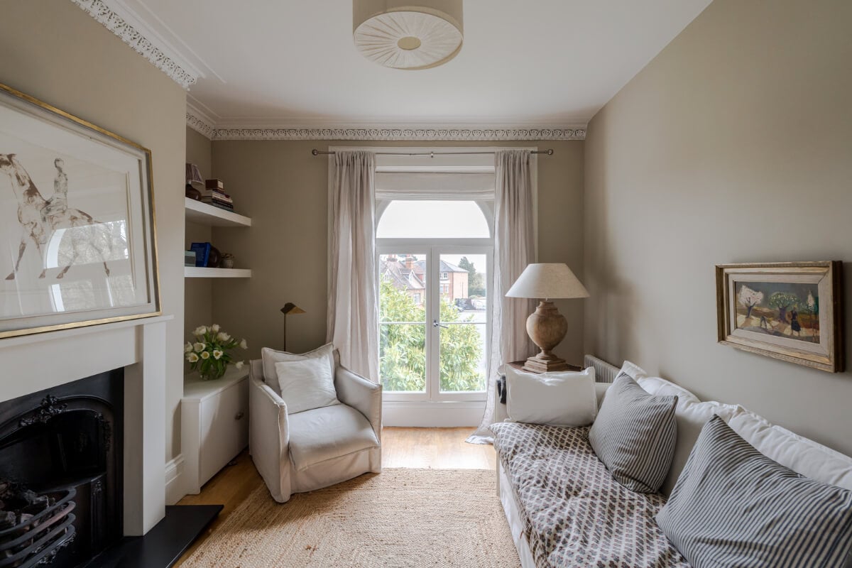 A Serene Color Palette and Arched Windows in a Small English Apartment 1 serene living room jute rug arched window fireplace