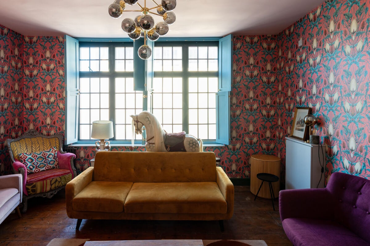 Colorful Design and Historic Features in a Charming English Home 8 sitting room blue-painted shutters colorful wallpaper nordroom