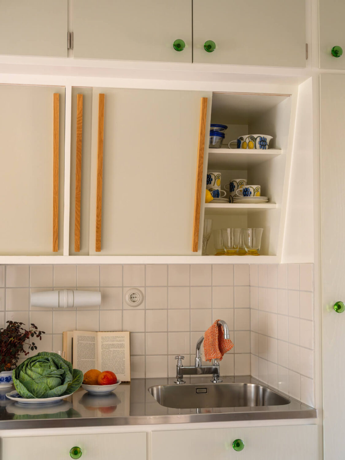A Tiny Apartment Filled with Books and a Midcentury-Style Kitchen 19 slanted upper cabinets detail