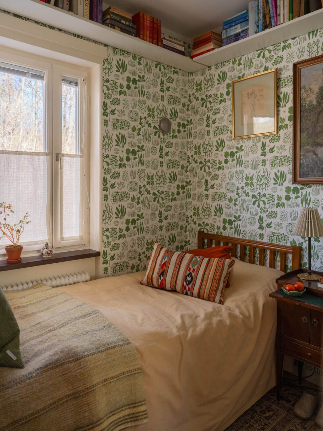 A Tiny Apartment Filled with Books and a Midcentury-Style Kitchen 22 small bedroom green wallpaper high corner bookshelf