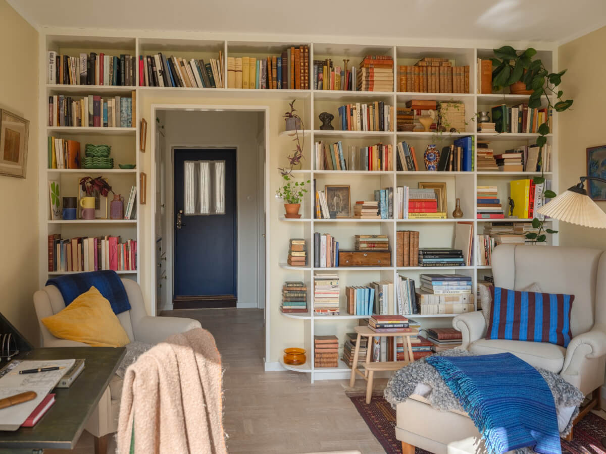 A Tiny Apartment Filled with Books and a Midcentury-Style Kitchen 11 small living room yellow walls bookshelves around doorway