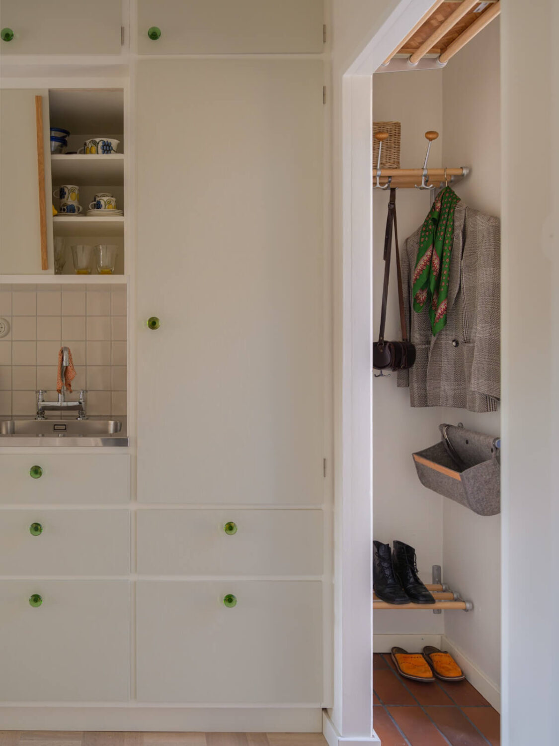 A Tiny Apartment Filled with Books and a Midcentury-Style Kitchen 20 tiny entry hall tile floor