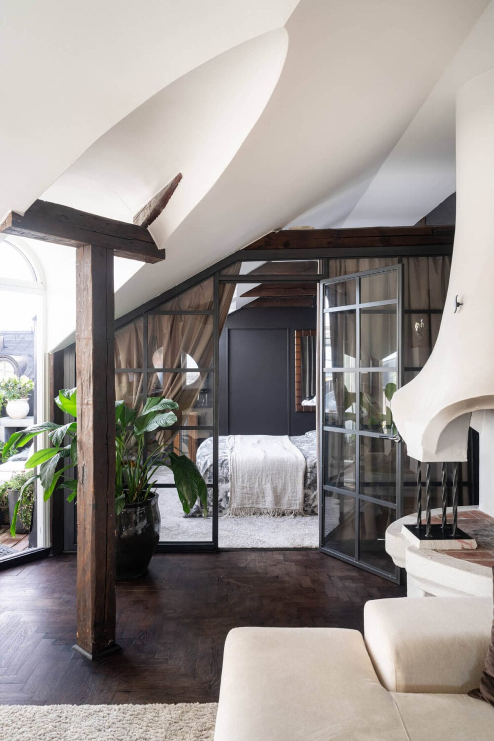 A Stylish Black and White Penthouse Apartment in Stockholm 2 top floor apartment exposed beams industrial glass wall to bedroo nordroom