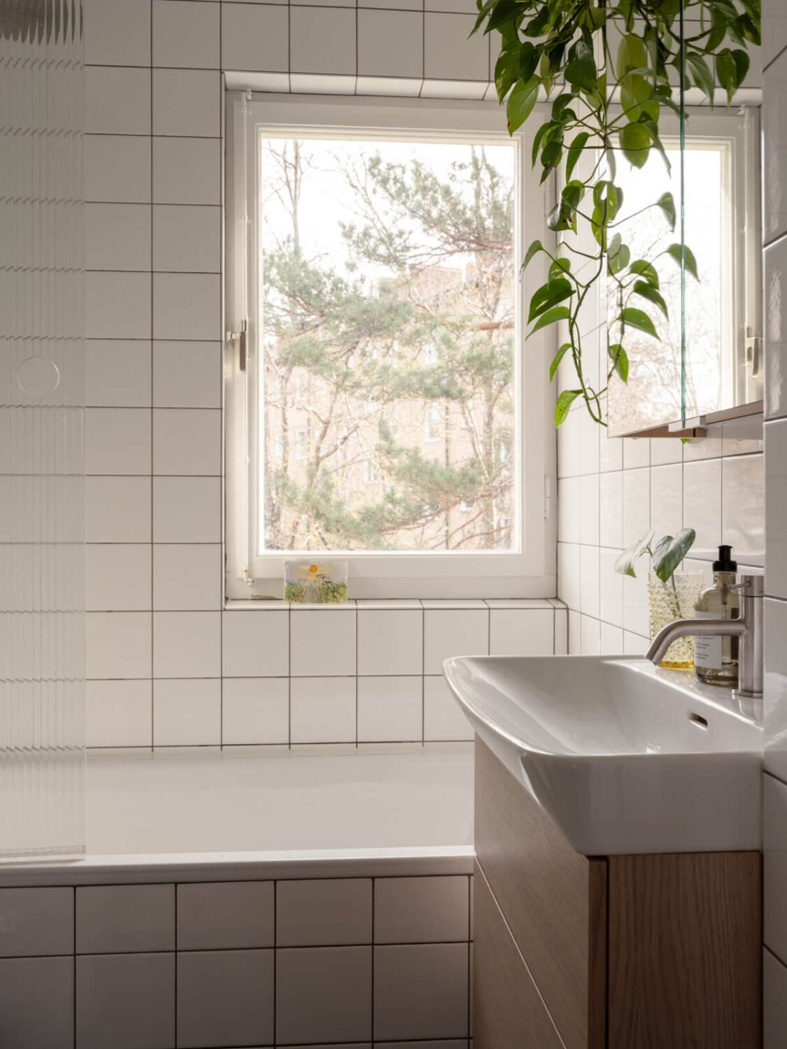 Color Accents in a Renovated Midcentury Apartment in Stockholm 21 white bathroom with reeded glass shower wall Color Accents in a Renovated Midcentury Apartment in Stockholm