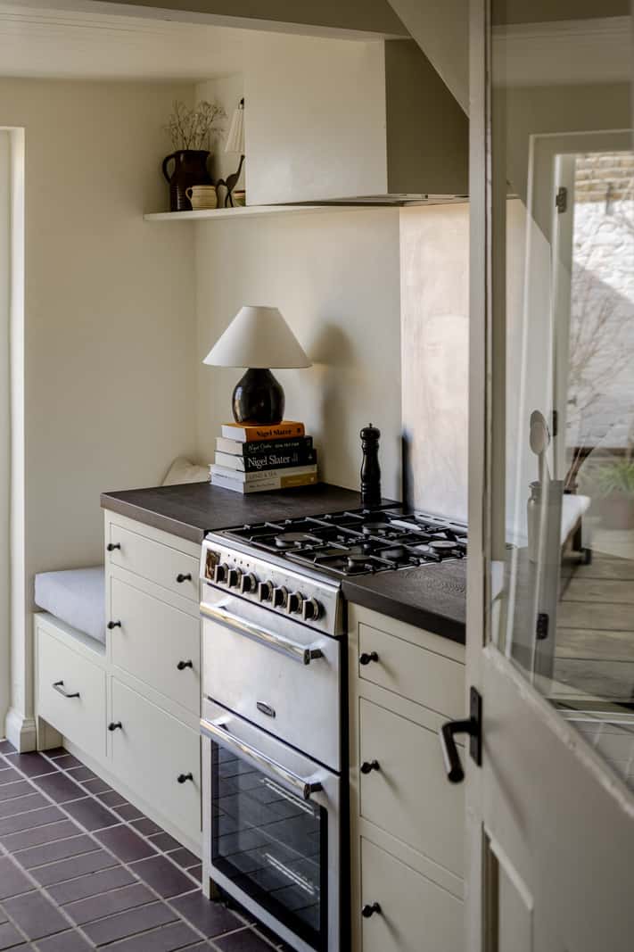 Reclaimed Materials and Custom Storage in a Serene London Home 12 white kitchen black tiles