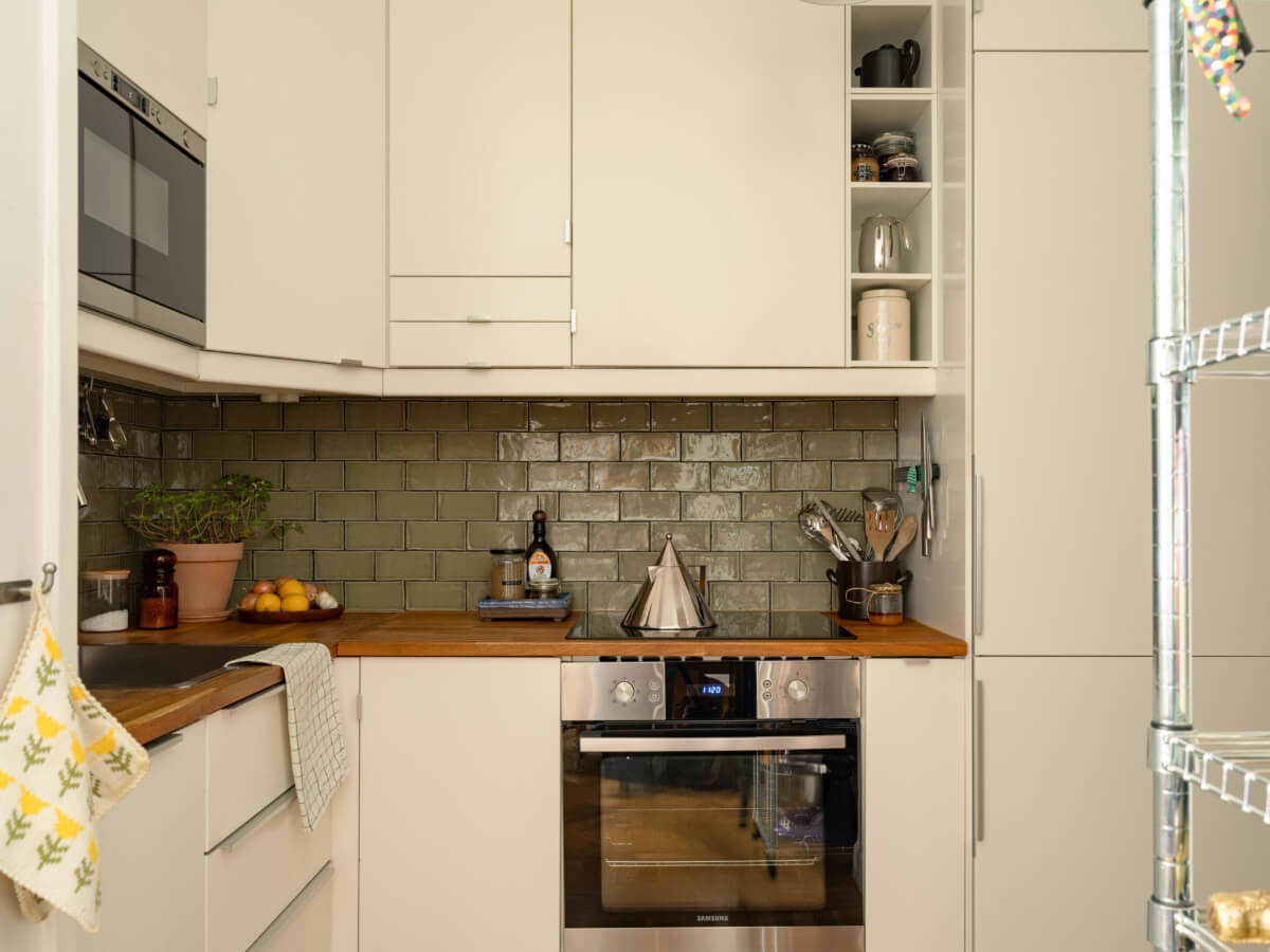 A Small, Cozy Apartment with Built-in Storage and Bookshelves 11 white kitchen green backsplash tiles
