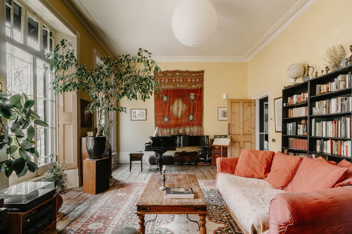 A Grand Regency-Style House with a Mature Garden in London 1 yellow living room raw wooden floorboards bookshelves large windows