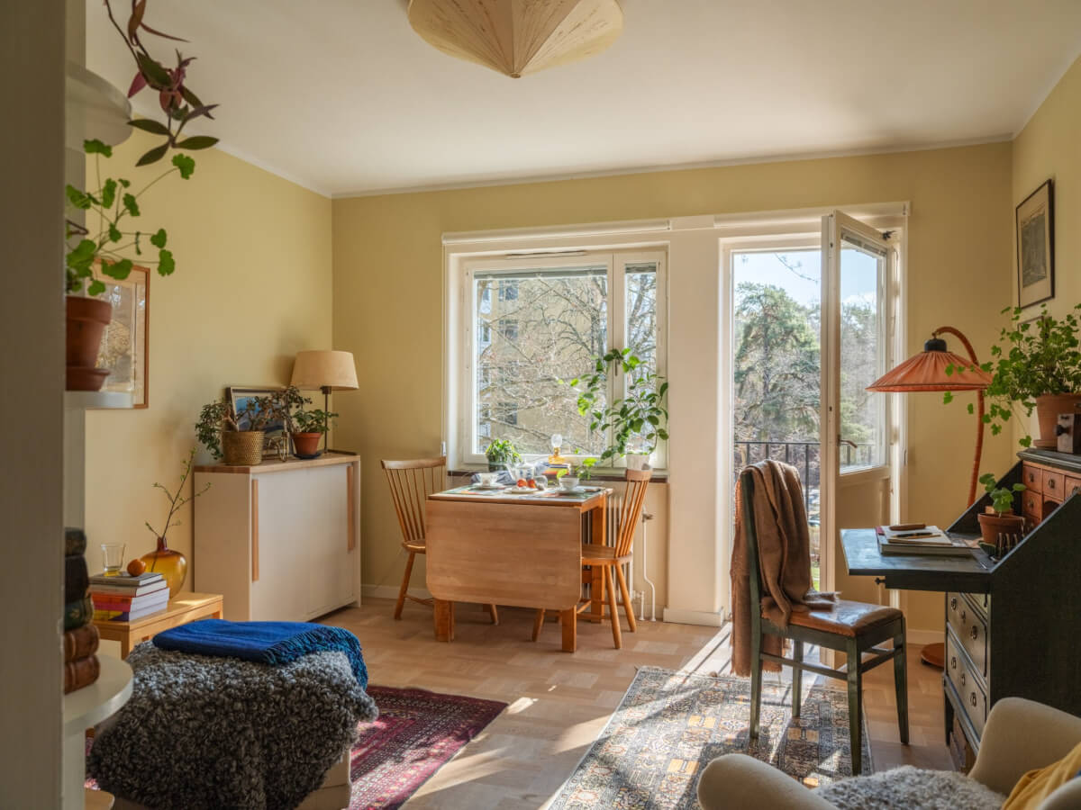 A Tiny Apartment Filled with Books and a Midcentury-Style Kitchen 1 yellow walls small living room antique desk dutch parquet floor
