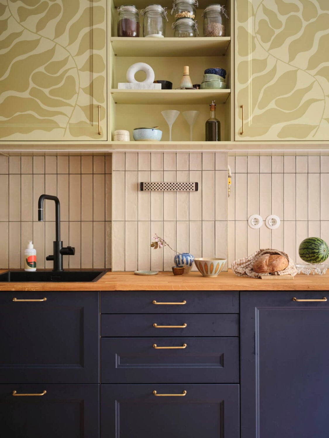 A Fantastic Small Art Nouveau Apartment in Stockholm 5 blue and patterned green kitchen cabinets beige backsplash tiles wooden countertop nordroom