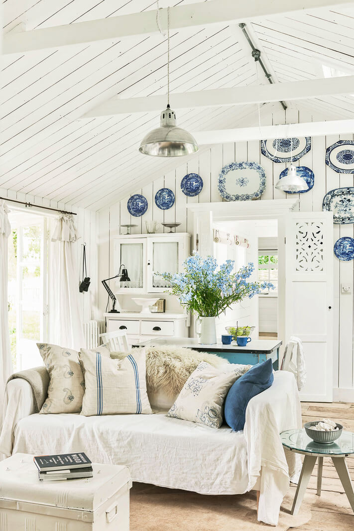 A Bright New England-Style Home with a Lush Garden 17 blue and white living space pitched ceiling