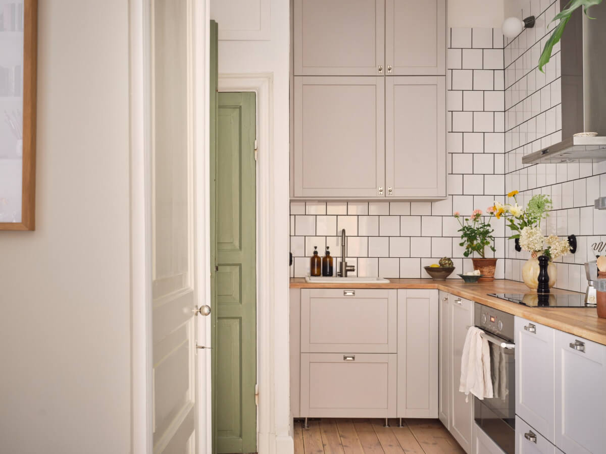 A Cozy, Tiny Apartment with a Golden Yellow Bedroom 9 classic light gray kitchen wooden countertop