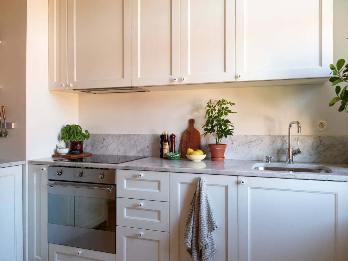 A Light-Filled Stockholm Apartment with Bright Color Pops 19 classic white cabinets marble countertop