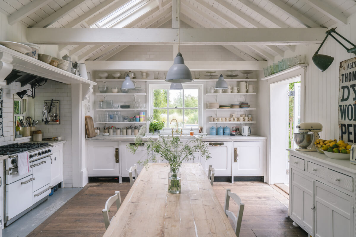 A Bright New England-Style Home with a Lush Garden 2 coastal style kitchen pitched ceiling white cabinets