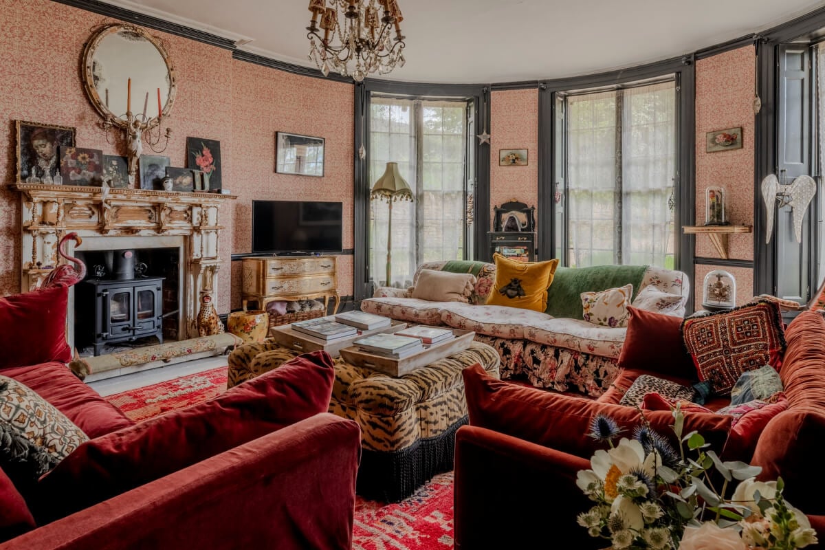 Pearl Lowe and Danny Goffey’s Eclectic Gothic Somerset Home Is For Sale 10 cozy living room vintage art rounded wall large windows wallpaper