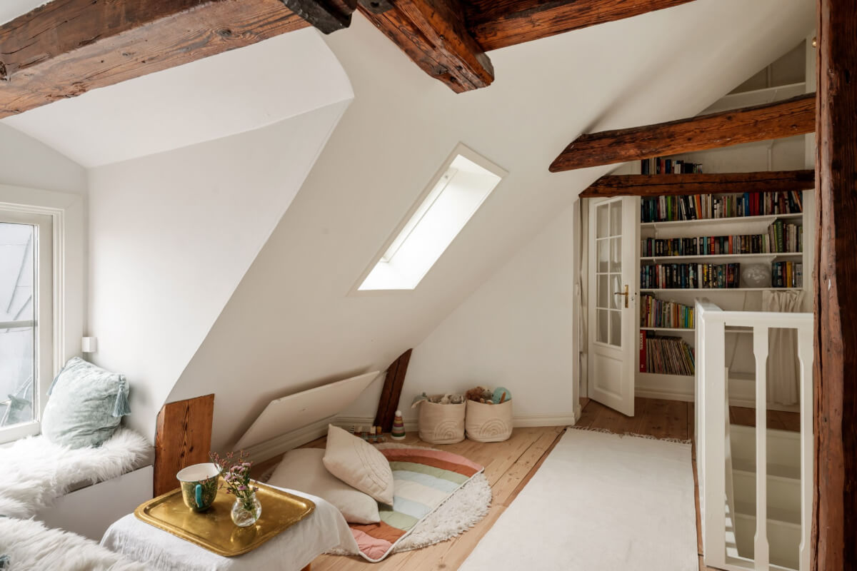 A Charming Attic Apartment in Stockholm's Gamla Stan 13 cozy reading room wooden beams slanted ceiling