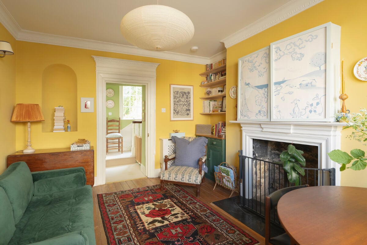 A Family Home with a Cheerful Color Palette in a Historic House 5 cozy yellow living room with fireplace and bookshelves