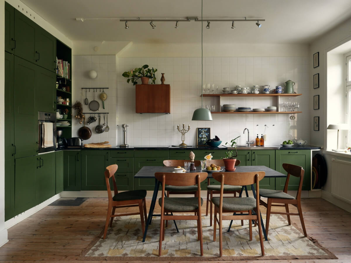 An Art Nouveau Apartment with a Deep Green Kitchen 1 deep green kitchen large dining table