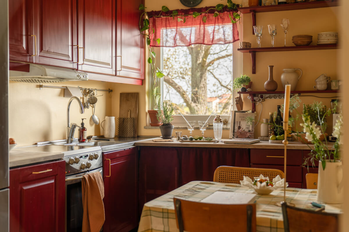A Stylish and Joyful Color and Material Palette in a Midcentury Apartment 11 deep red kitchen cabinets yellow walls