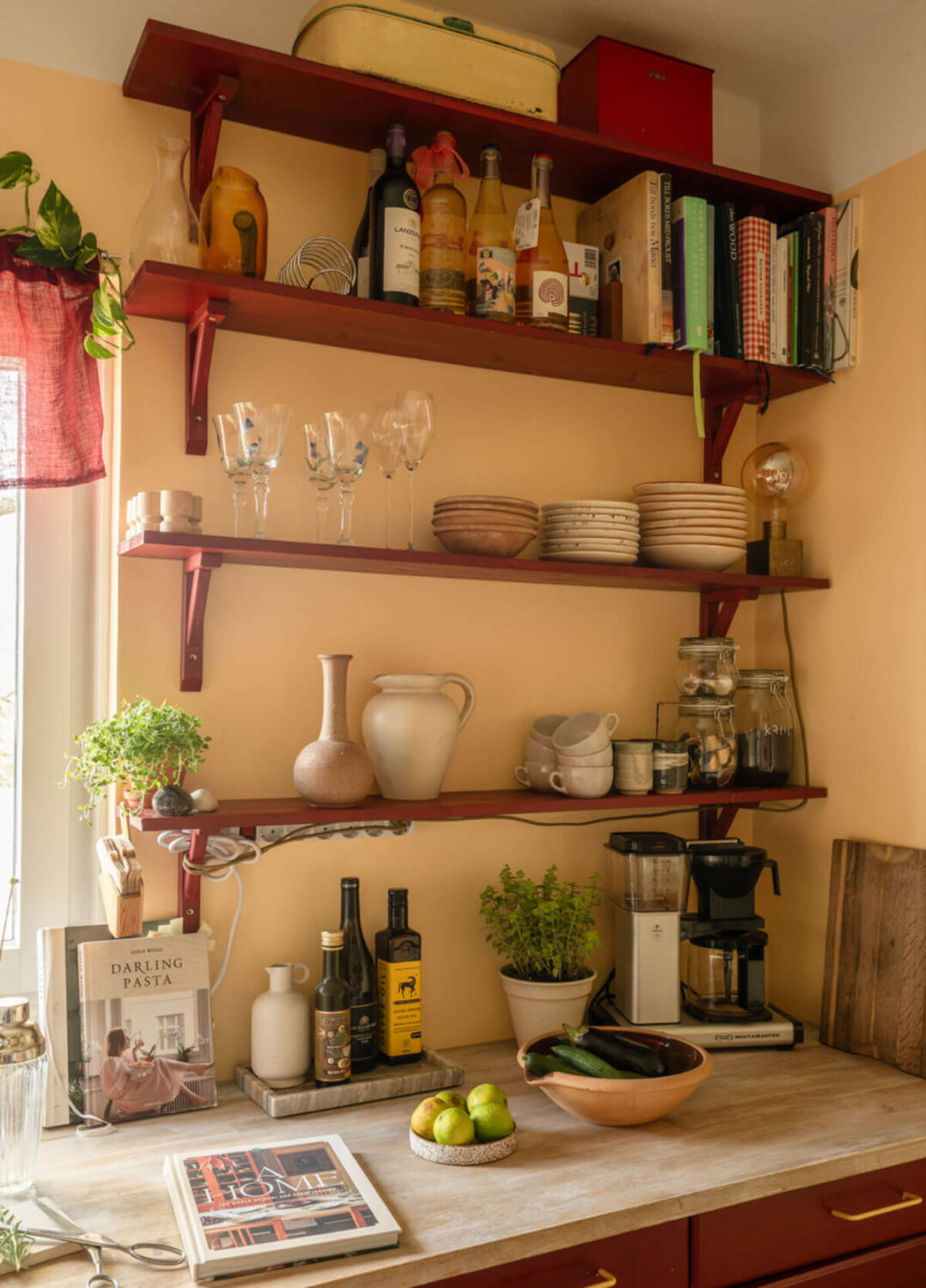 A Stylish and Joyful Color and Material Palette in a Midcentury Apartment 14 deep red kitchen shelves