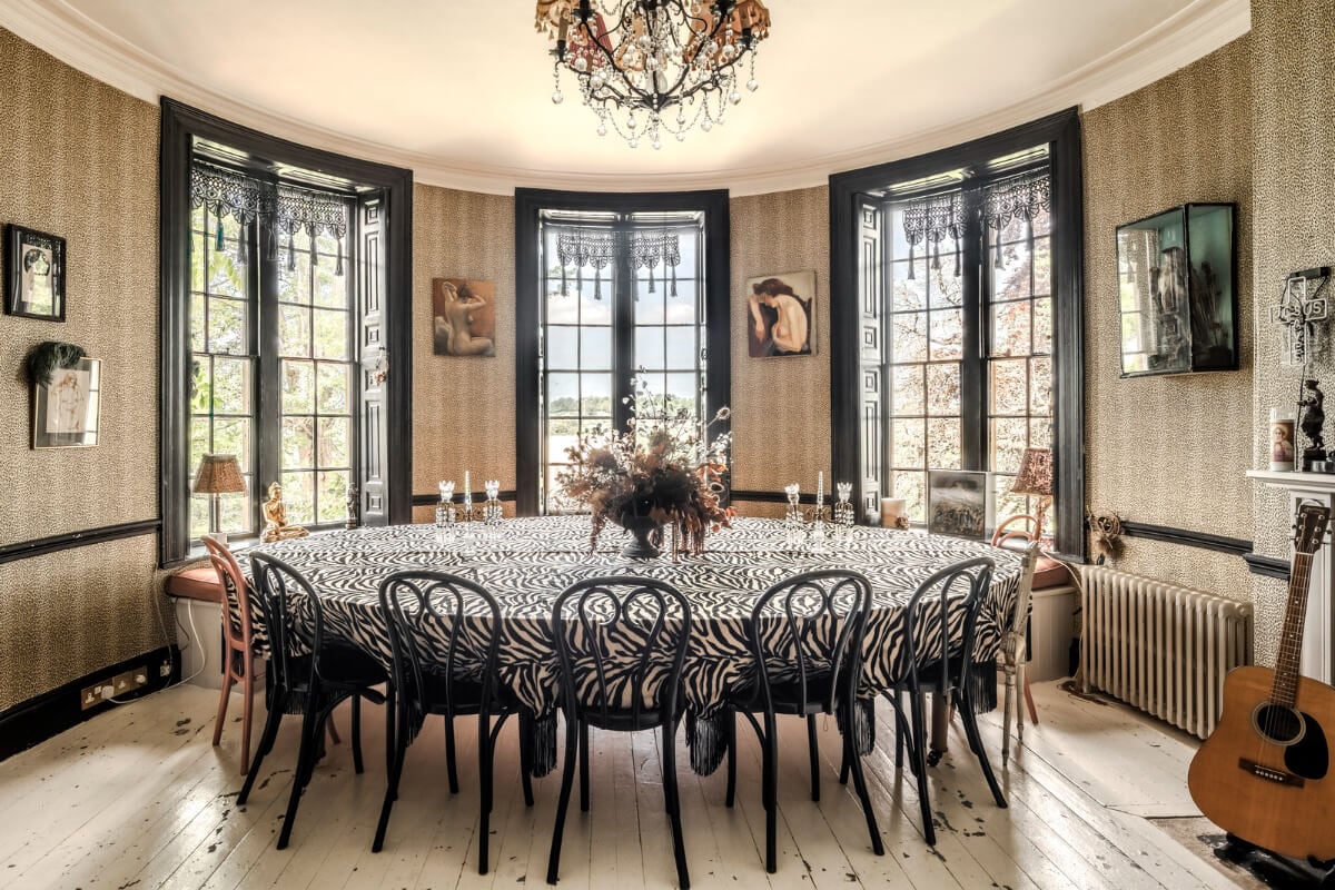 Pearl Lowe and Danny Goffey’s Eclectic Gothic Somerset Home Is For Sale 11 dining room large table dramatic black window frames wallpaper pearl lowe