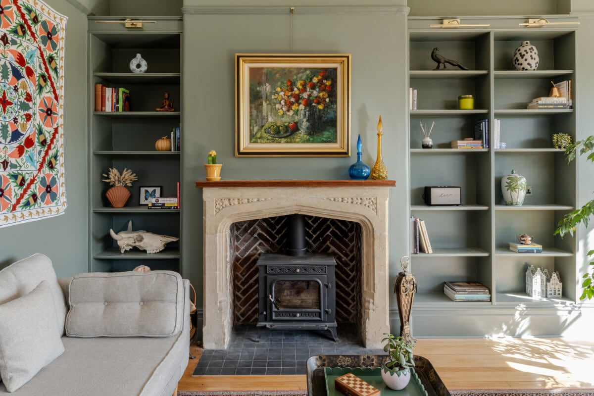 A Grand Edwardian Villa with a Yellow Kitchen and Coastal Views 12 fireplace bookshelves green sitting room