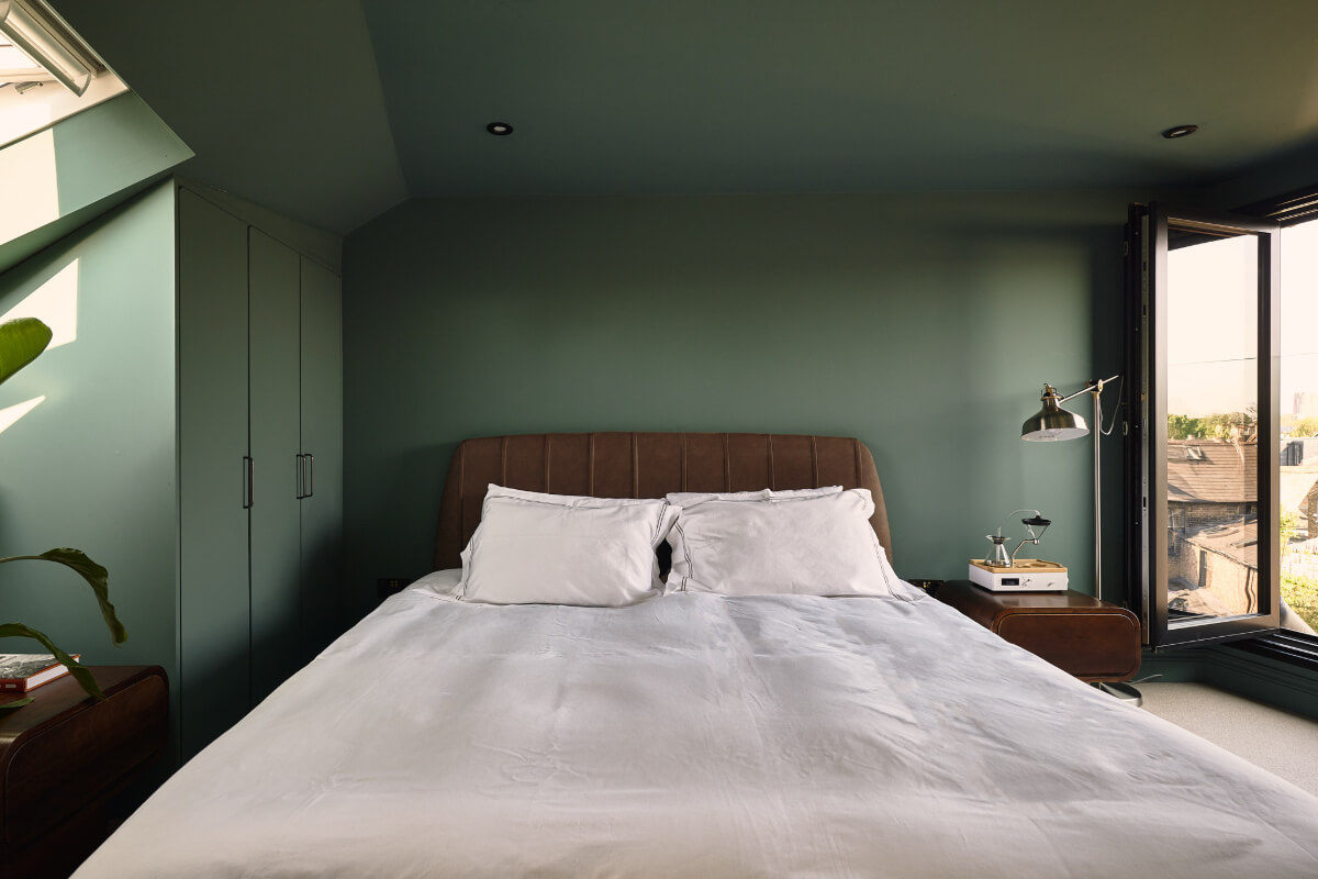 Moody Tones in a Restored and Extended Victorian Home in London 17 green bedroom with built-in wardrobes