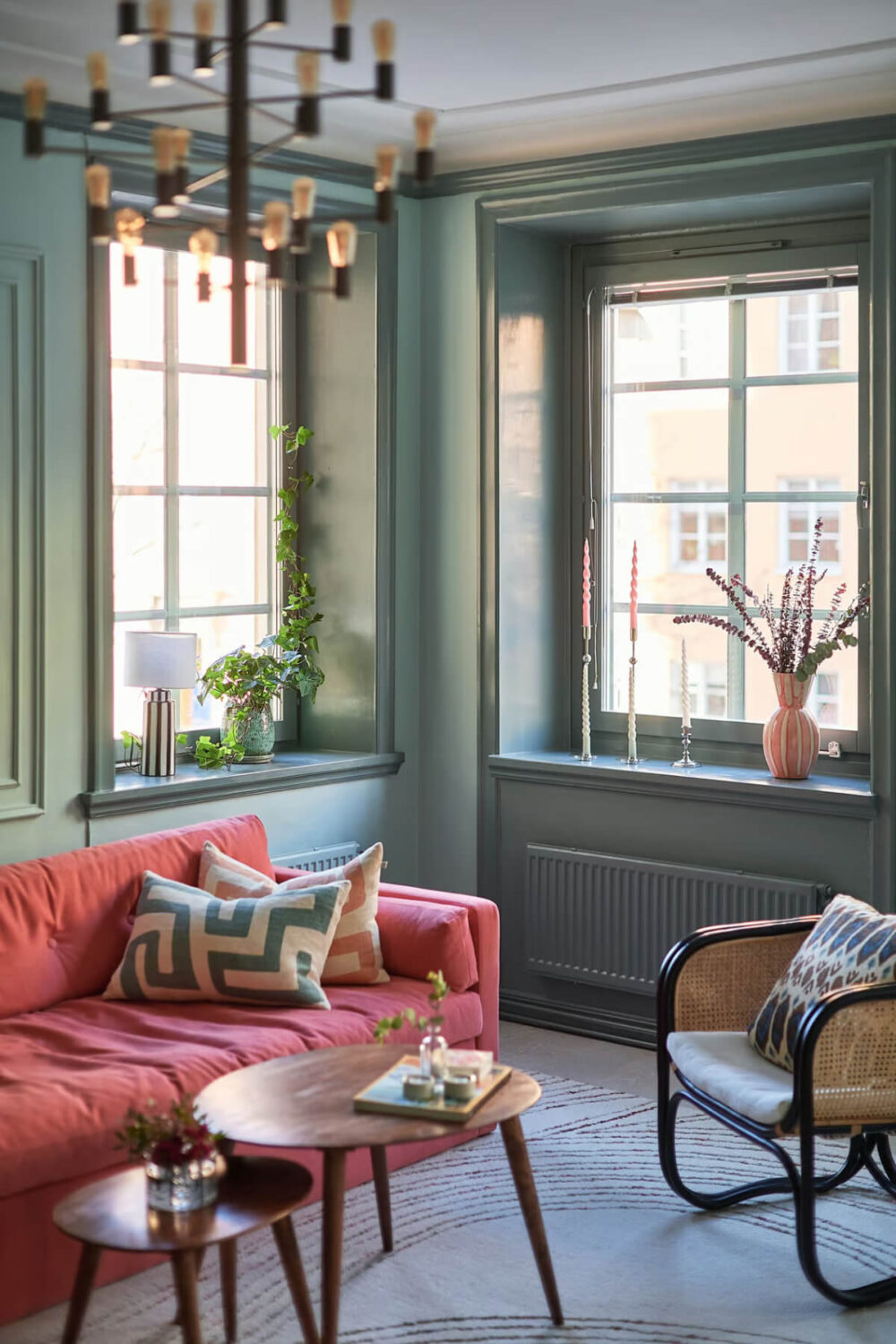 A Green Swedish Corner Apartment with an Open Floor Plan 4 green living room pink sofa