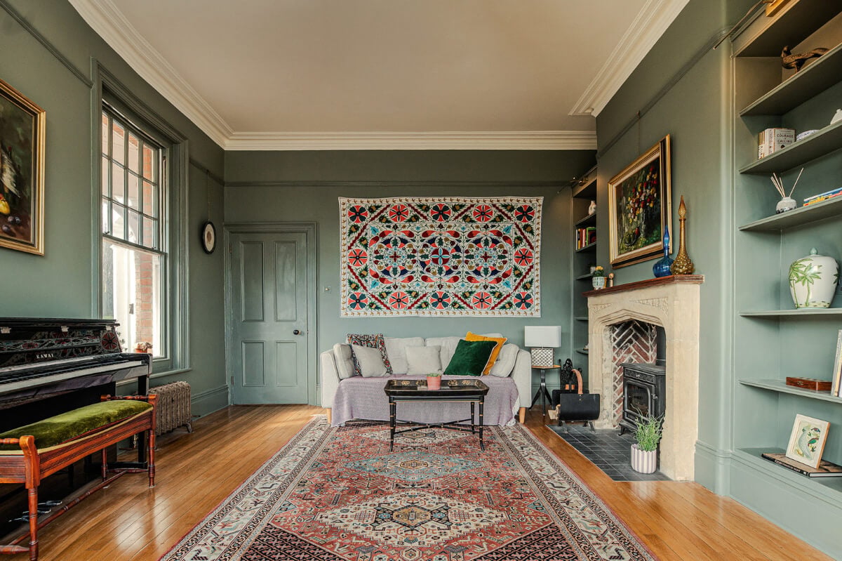 A Grand Edwardian Villa with a Yellow Kitchen and Coastal Views 11 green sitting room stone fireplace