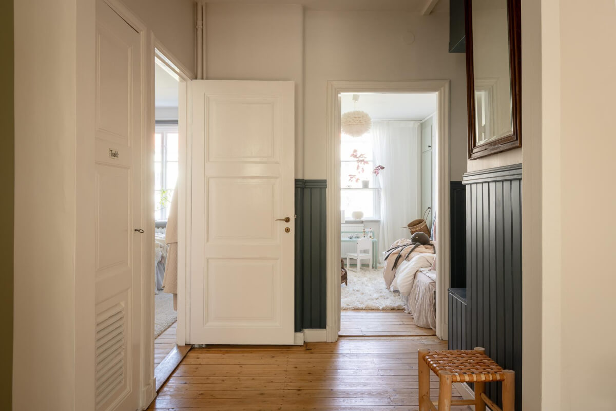 A Cozy Swedish Apartment with a Walk-In Pantry in the Sage Green Kitchen 27 hall blue paneling