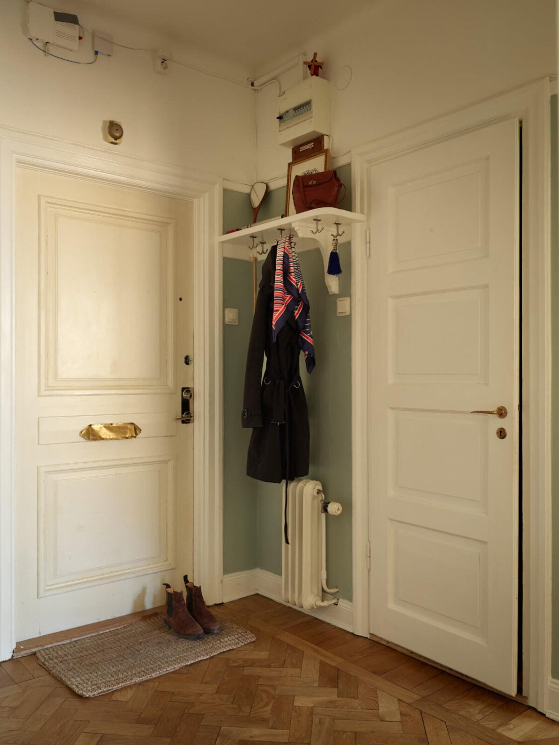 Warm Walls and Original Elements in a Swedish Studio Apartment 17 hall herringbone parquet floor hat shelf