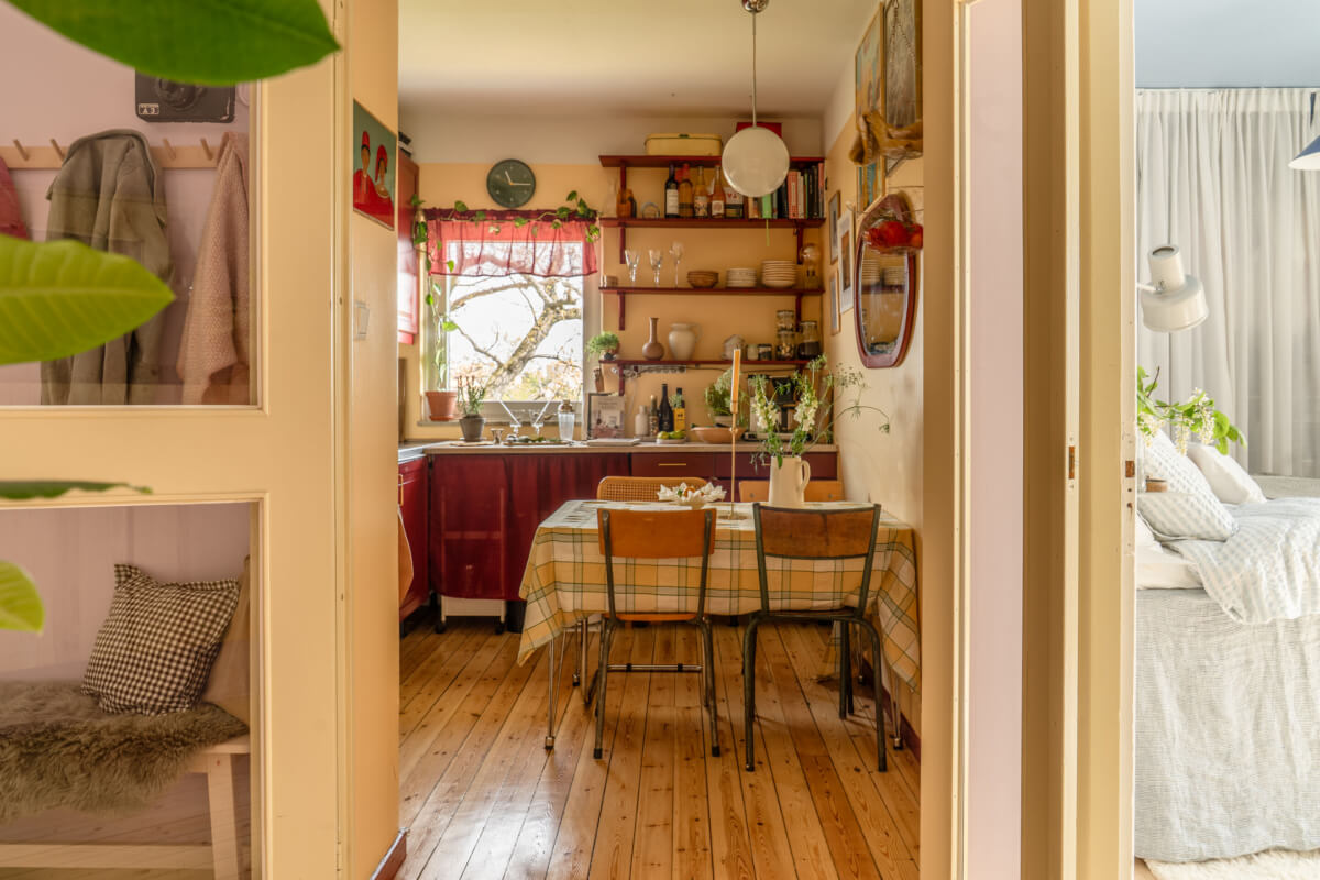 A Stylish and Joyful Color and Material Palette in a Midcentury Apartment 9 kitchen wooden floorboards yellow walls dining table
