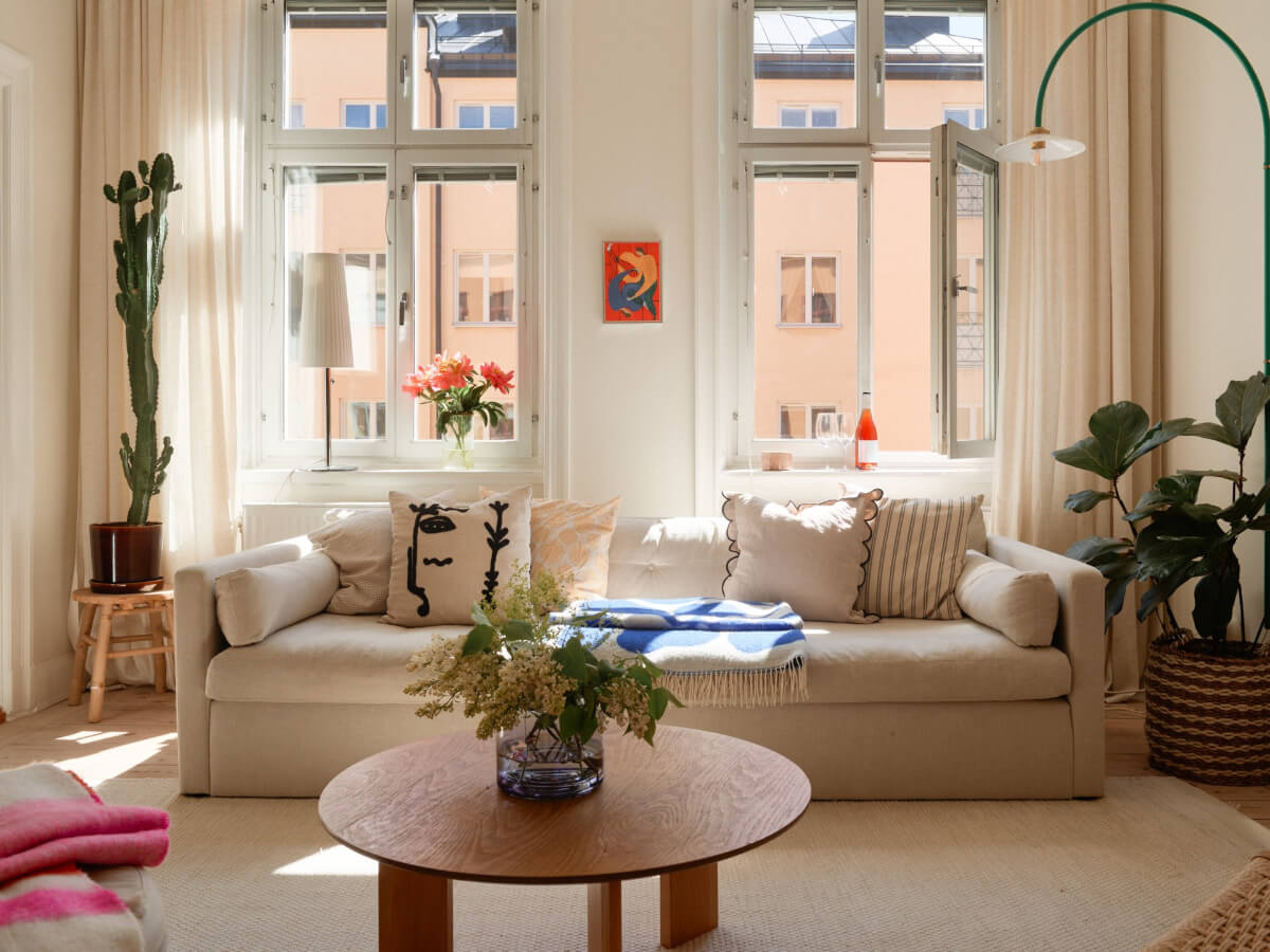 A Light-Filled Stockholm Apartment with Bright Color Pops 4 large windows living room