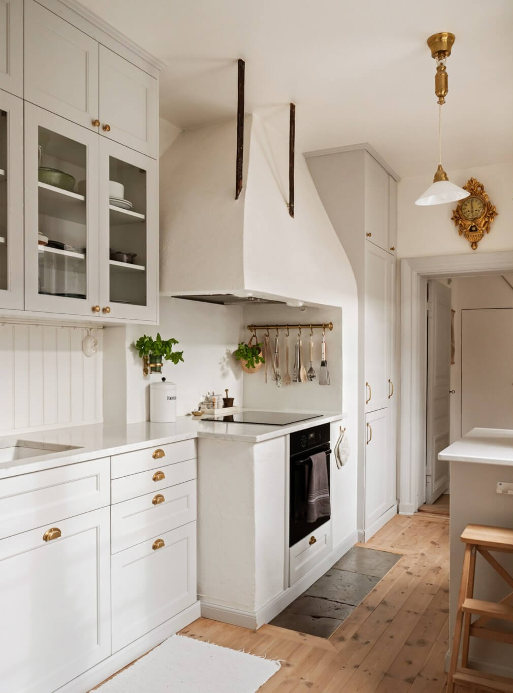 A Charming Attic Apartment in Stockholm's Gamla Stan 8 light classic kitchen brass fittings wooden floorboards