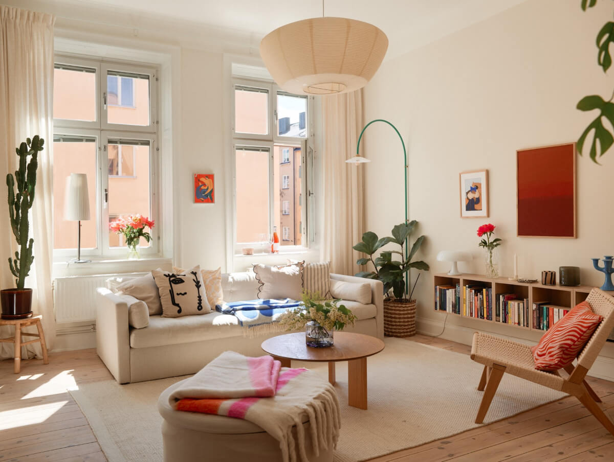 A Light-Filled Stockholm Apartment with Bright Color Pops 1 light scandinavian living room wooden floor green hanging lamp