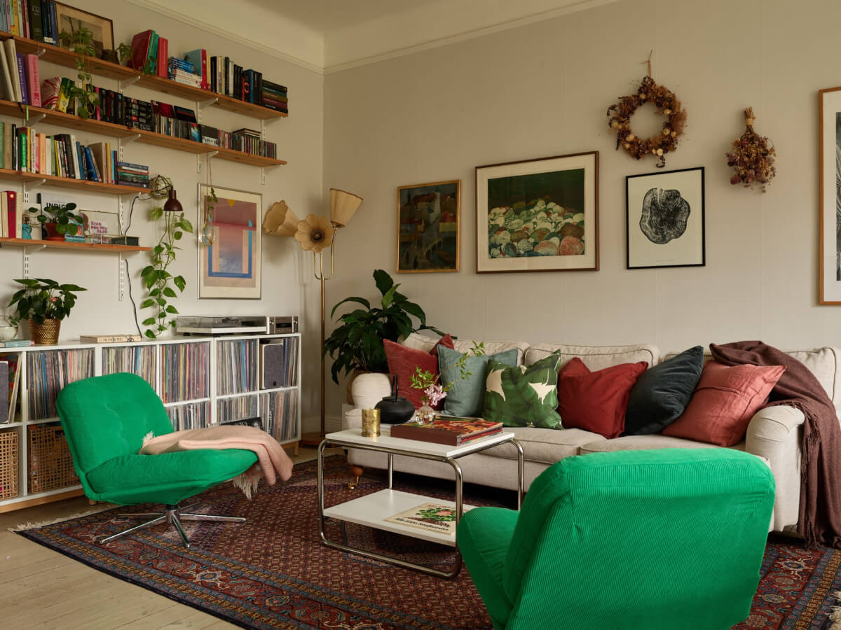 A Beautifully Renovated Early 20th-Century Apartment 5 living room green ikea chairs bookshelves music storage