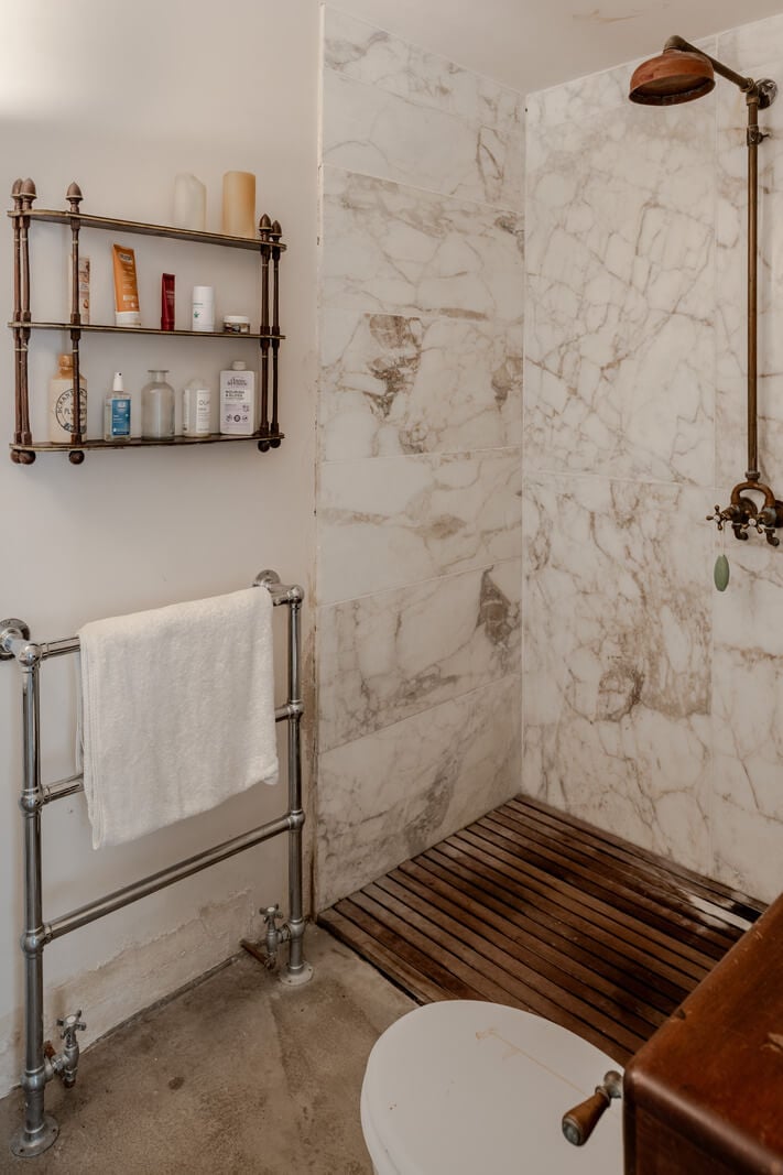 Grand, Light-Filled Spaces in a Gothic-Style English Coastal Home 26 marble tiled bathroom