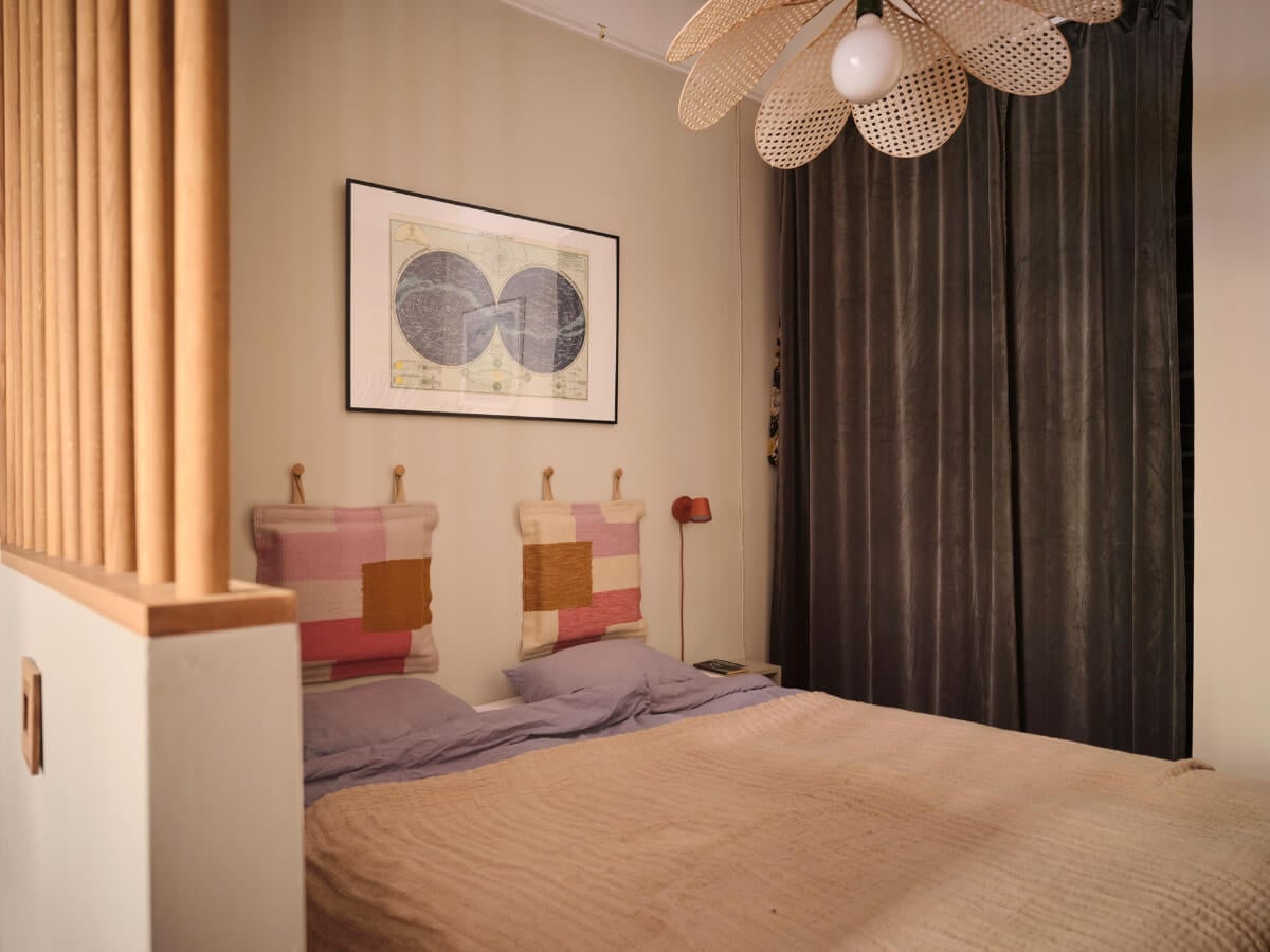 A Fantastic Small Art Nouveau Apartment in Stockholm 13 small bedroom colorful headboard cushions wardrobe behind velvet curtain nordroom
