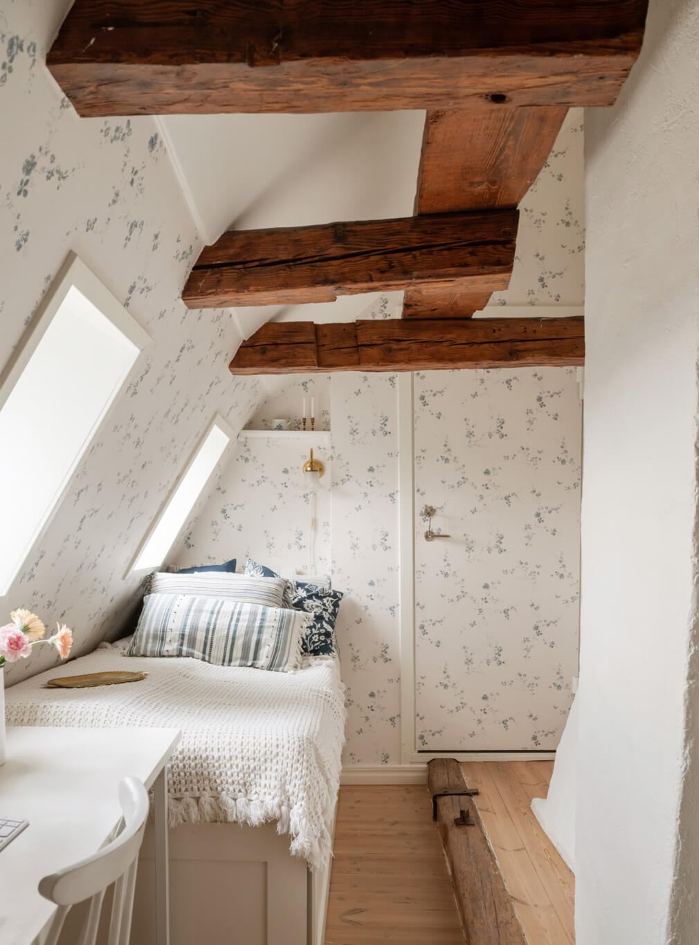 A Charming Attic Apartment in Stockholm's Gamla Stan 19 small bedroom wooden beams floral wallpaper