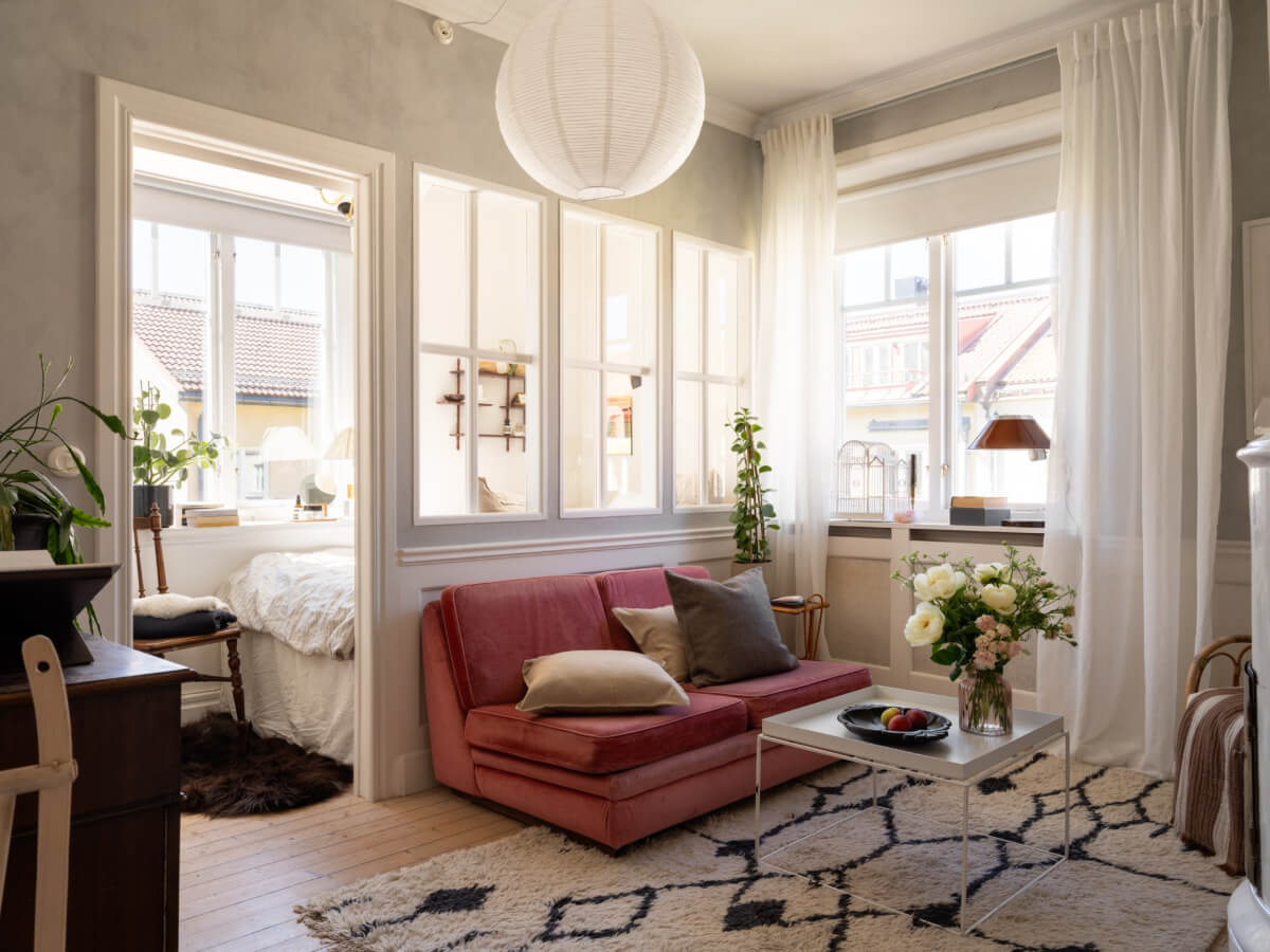 A Small Light-Filled Corner Apartment with Original Details 1 small living room pink sofa inner window to bedroom
