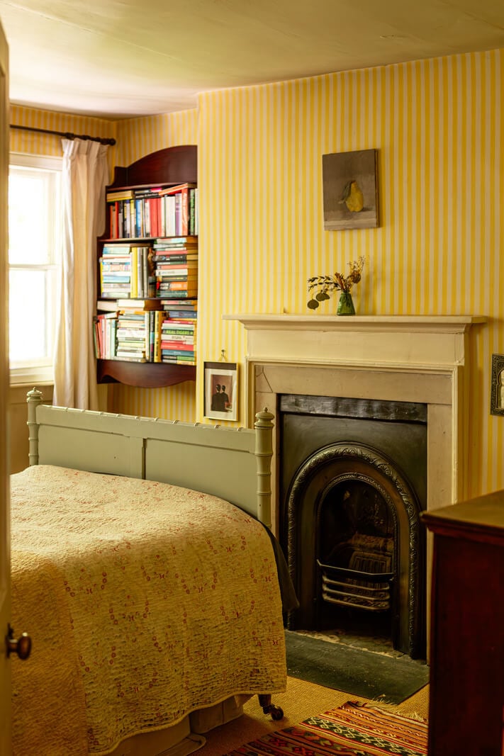 A Carefully Restored Georgian Townhouse in East London 21 striped yellow wallpaper fireplace bedroom