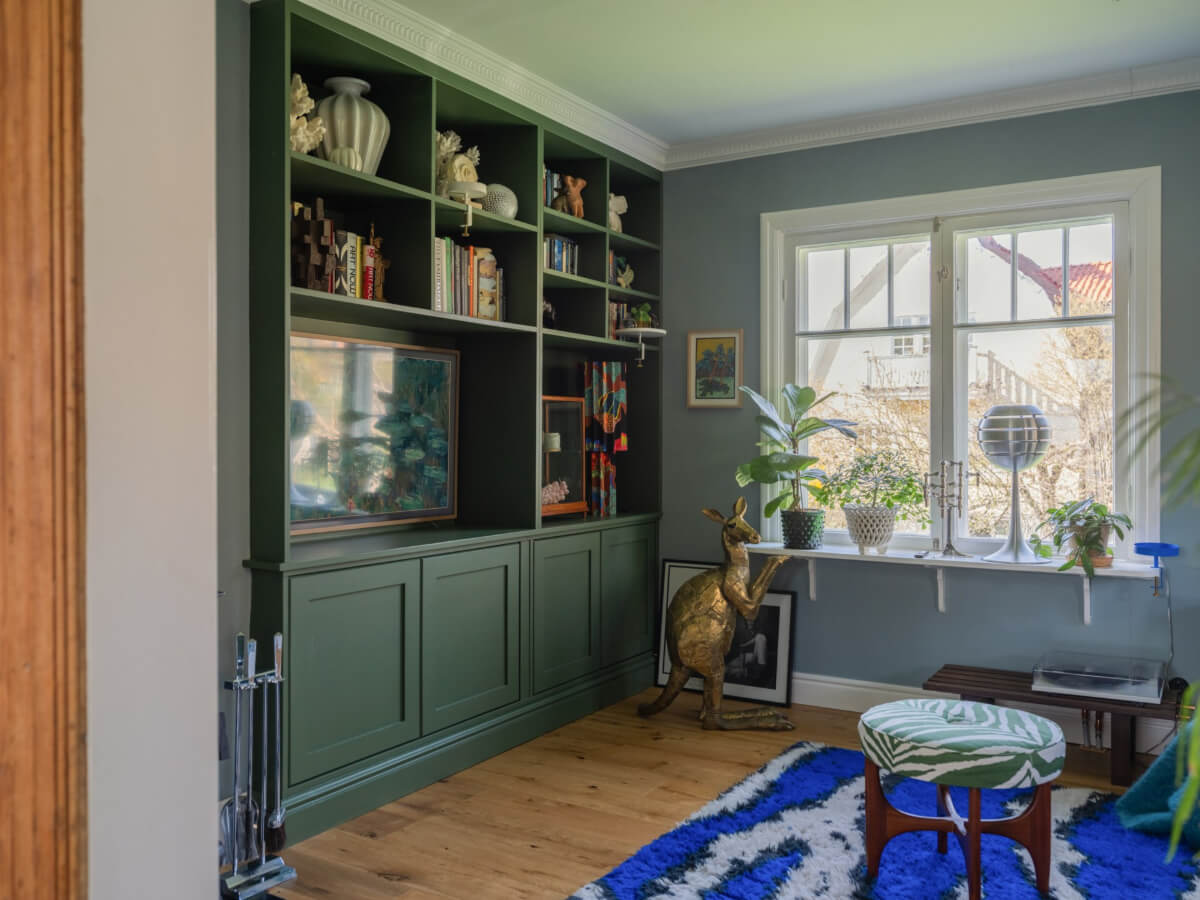 An Early 20th-Century Family Home Decorated with Color and Art 5 television room green built-in cabinets cobalt blue rug