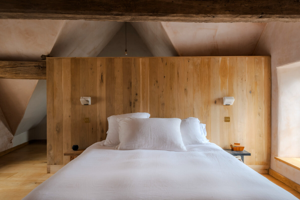 White-Washed Walls and Rustic Elements in a 17th Century Townhouse 23 timber headboard hiding en-suite bathroom