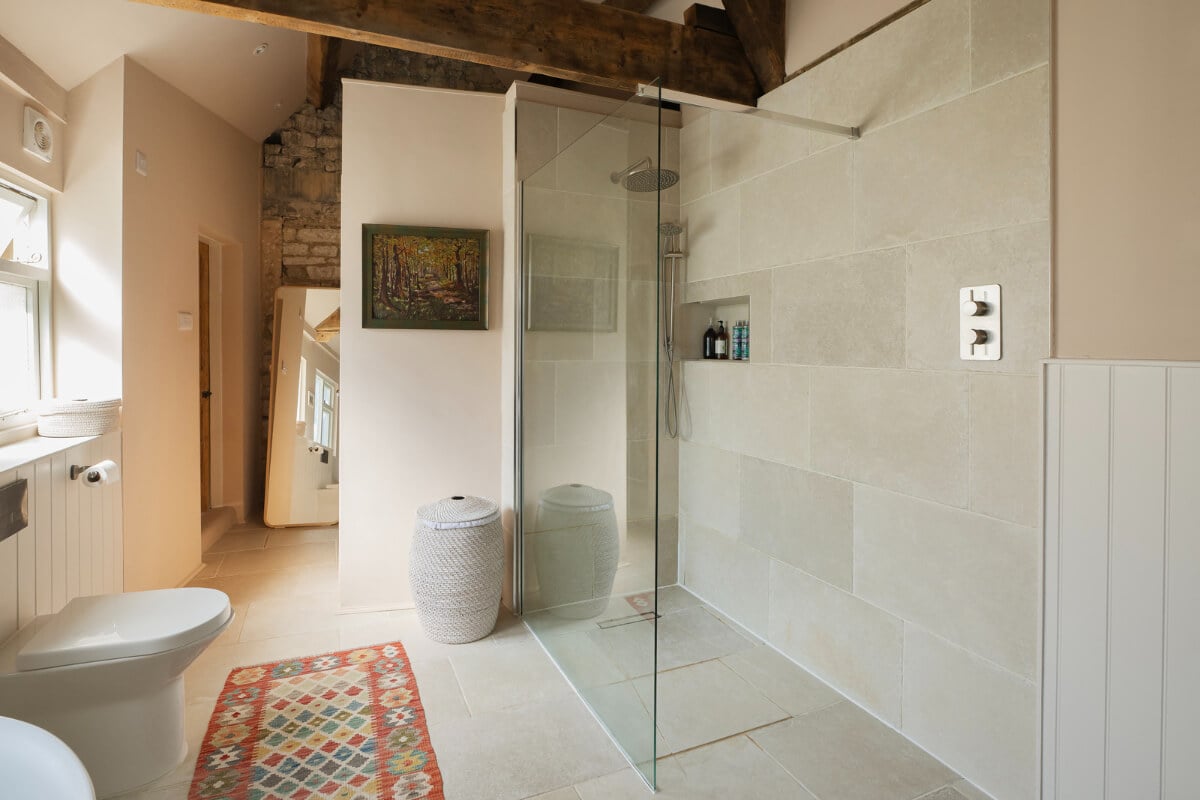 A Family Home with a Cheerful Color Palette in a Historic House 20 walk in shower bathroom exposed brick and beams