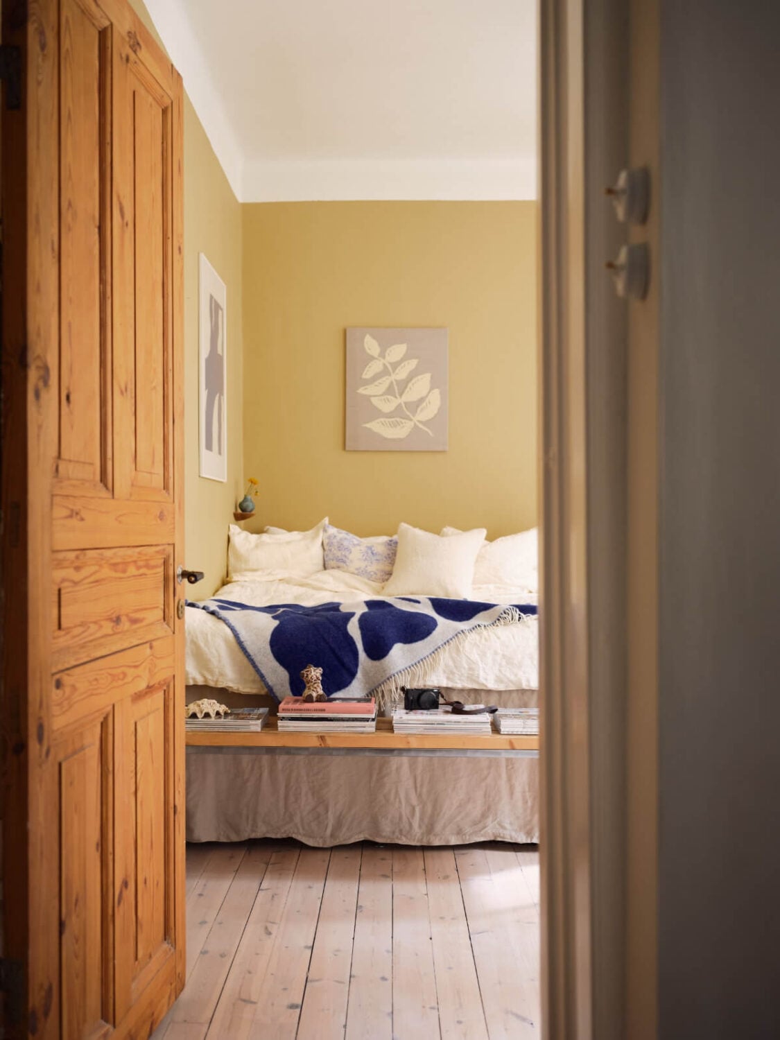 A Cozy, Tiny Apartment with a Golden Yellow Bedroom 11 wooden door entry bedroom