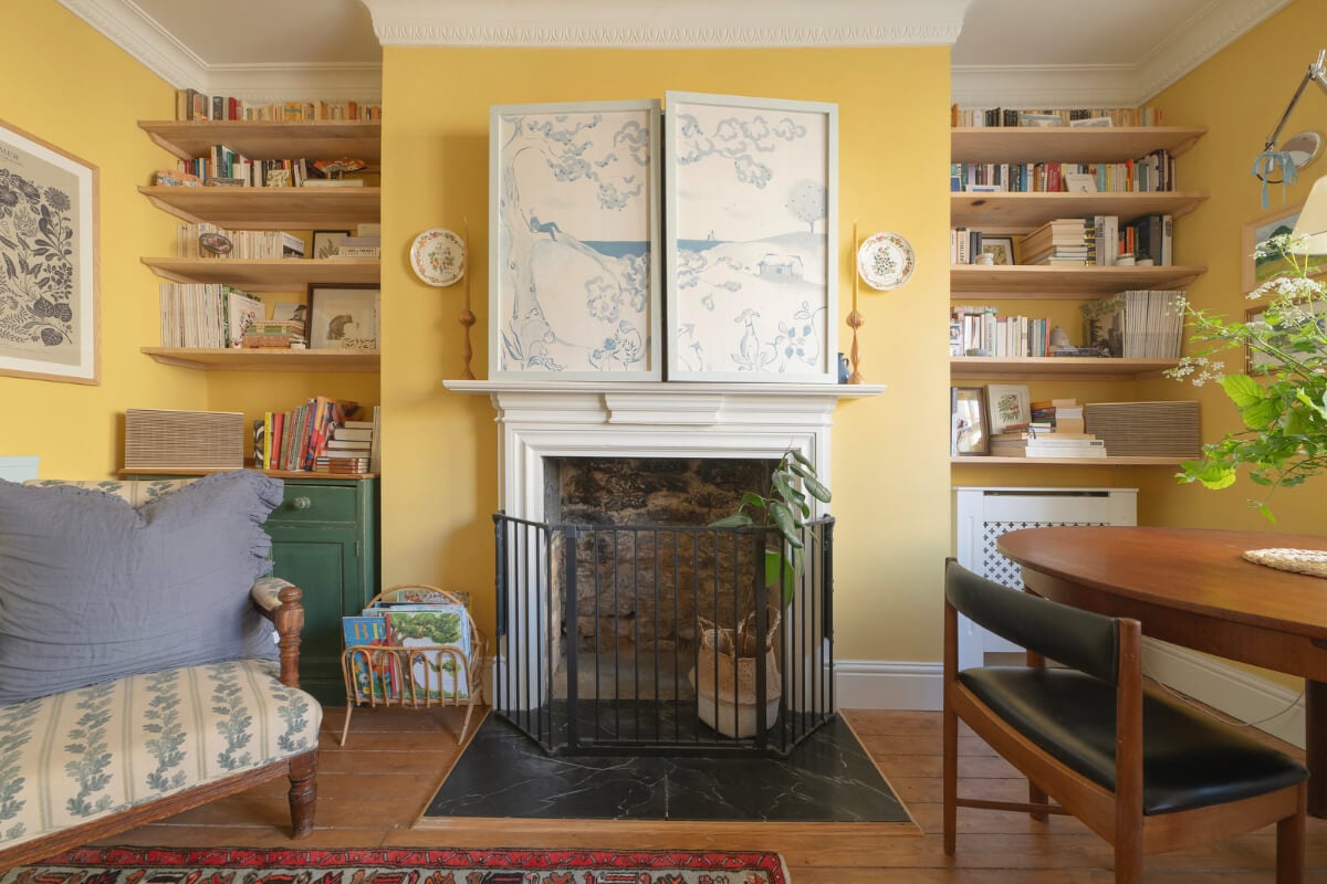 A Family Home with a Cheerful Color Palette in a Historic House 2 yellow living room fireplace bookshelves