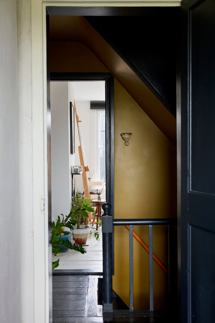 Cozy Living Spaces and Limewash Walls in an Artist's English Home 18 first floor landing black-painted wooden floorboards