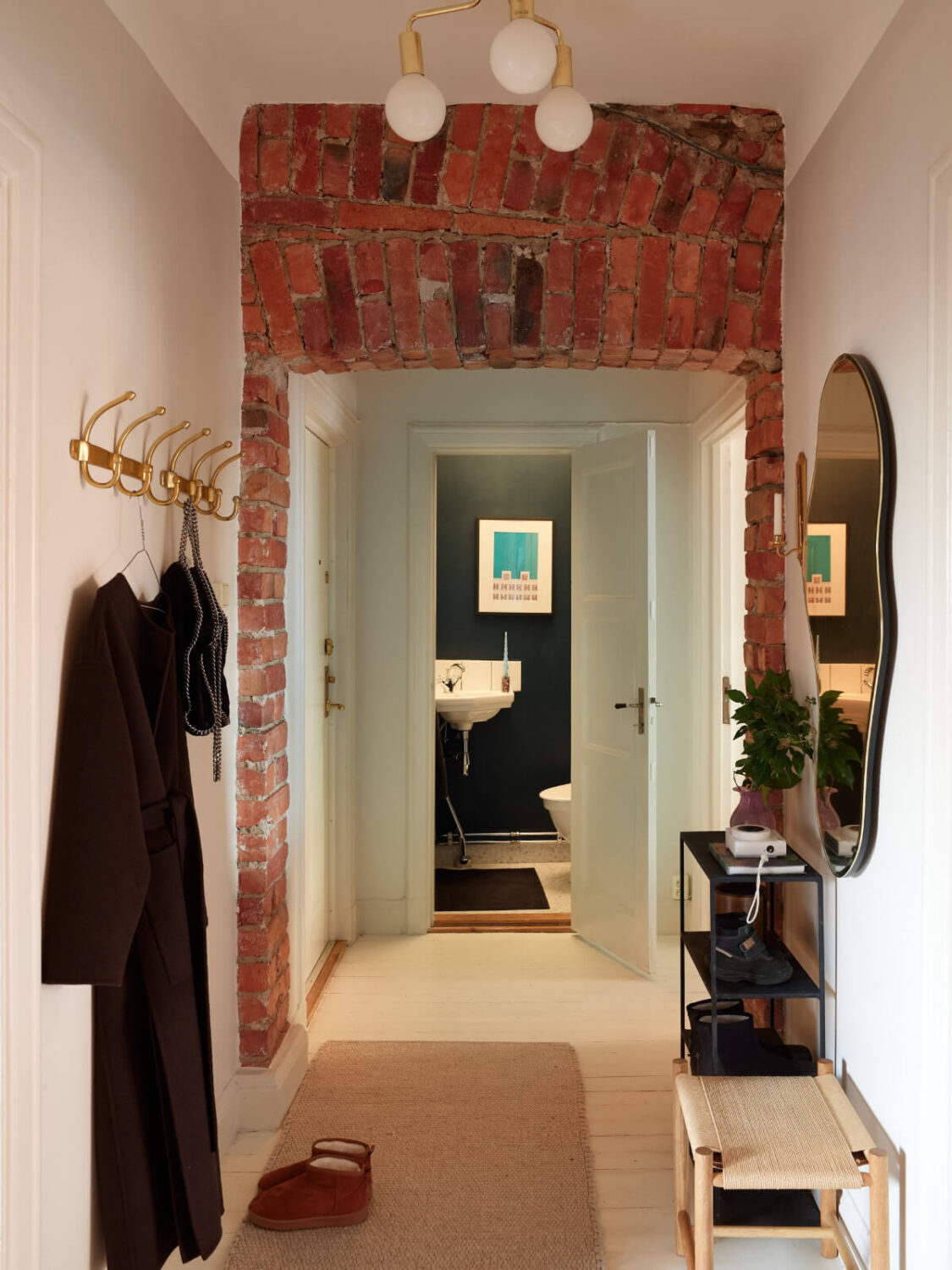 Historic Charm and an Industrial Glass Wall in a Stockholm Apartment 21 hall exposed brick doorway