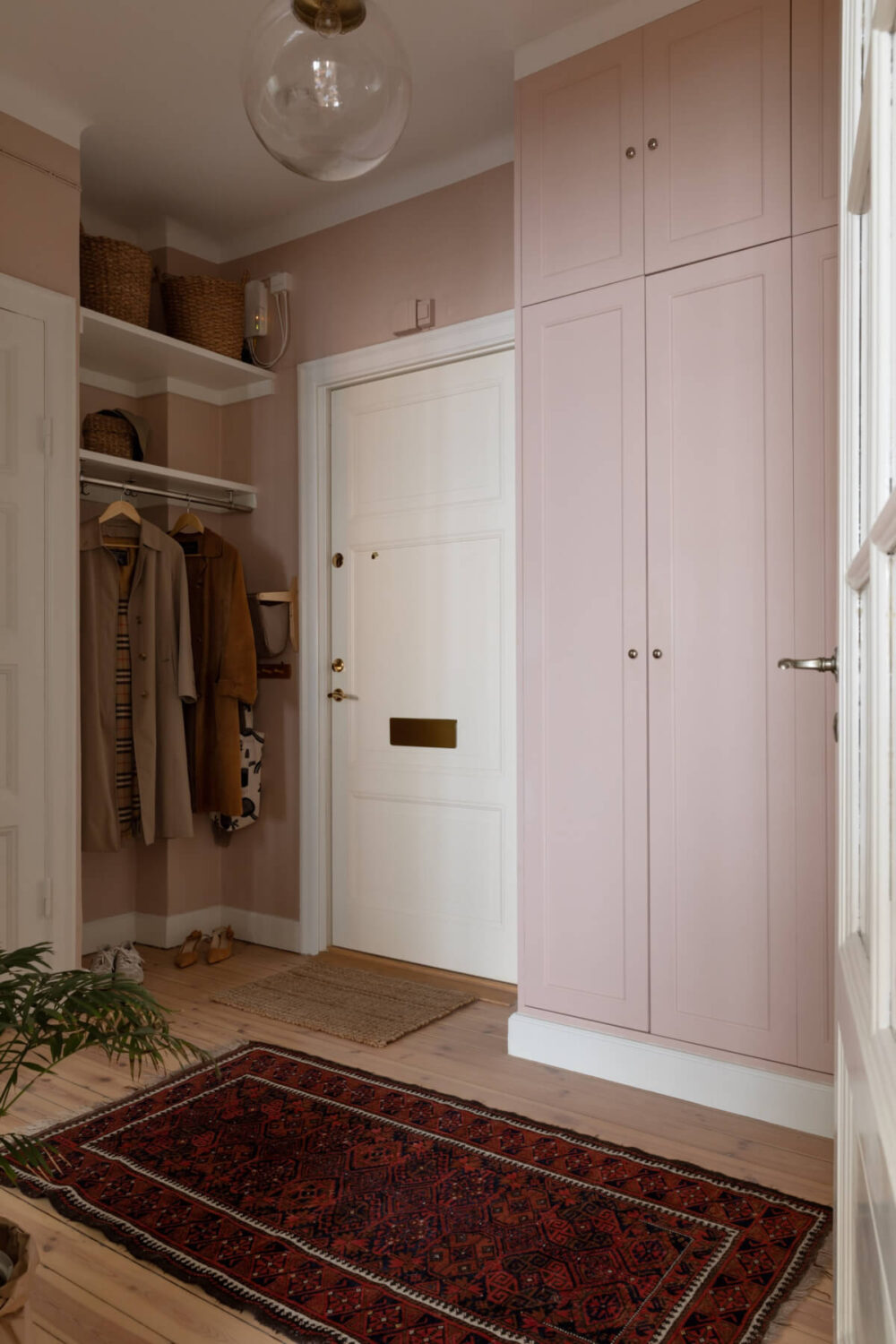 A Nice Color Palette and Original Elements in a Cozy 1930s Apartment 22 hall with pink walls and built-in wardrobes
