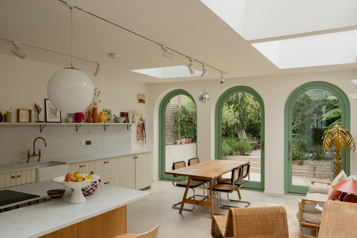 A Victorian Family House with a Tuscan-Inspired Kitchen Extension 7 kitchen extension green arched windows wooden dining table