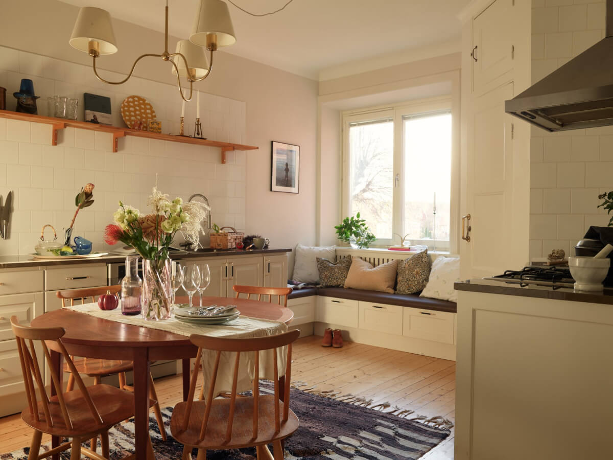 Historic Charm and an Industrial Glass Wall in a Stockholm Apartment 1 kitchen with round table and window seat